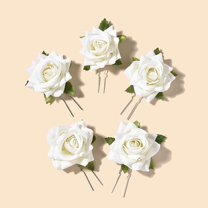 Set of five elegant white rose U-shaped bridal hair pins with green leaves on beige background