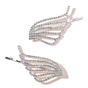 Close-up of sparkling angel wing hairpins with white rhinestones and silver metal base