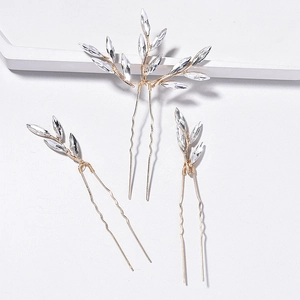 Detail view of bridal hair pin set with golden wires and leaf-shaped crystals for wedding