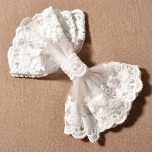 Détail de la pince à cheveux élégante en dentelle blanche avec broderie florale