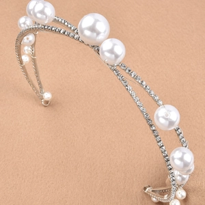 Close-up of handmade bridal headband with white pearls and sparkling rhinestones
