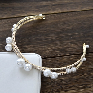 Macro shot of gold bridal headband featuring layered pearls and sparkling rhinestones