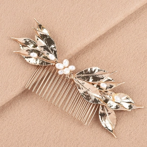 Close-up of gold leaf hair comb featuring delicate white pearls and handmade wire wrapping