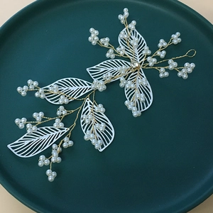 Handmade bridal hair accessories with white leaves and pearls on golden wire