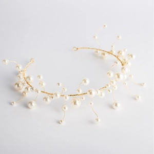 Handmade bridal headband with white pearls on a gold wire frame for wedding hairstyles