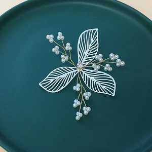 Detail view of handmade bridal hair combs with white petal leaves and pearl beaded wire