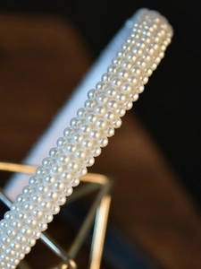 Close-up of elegant bridal headband with multiple rows of glossy white pearls for weddings