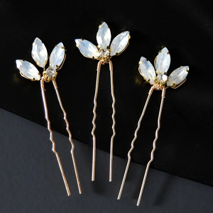 Dettaglio di tre forcine da sposa con base a U dorata e strass simili a opale elegante