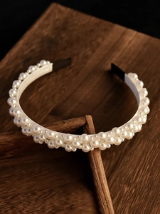 Detail view of double-layer faux pearl headband with elegant glossy finish for weddings