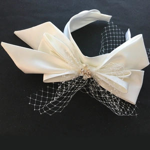 Detailed view of bridal satin headband with lace veil, pearls and rhinestone flower clusters