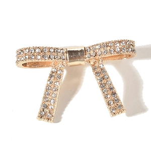 Dettaglio del fermaglio per capelli a fiocco con strass brillanti su base in metallo dorato