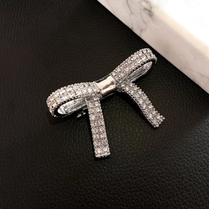Elegante fermaglio per capelli a fiocco con strass scintillanti su sfondo marmo