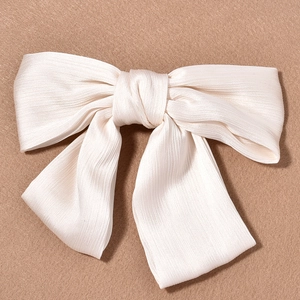 Close-up of cream white pleated ribbon hair clip with elegant layered fabric texture