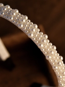 Close-up of elegant faux pearl headband with varying bead sizes for bridal wedding hair