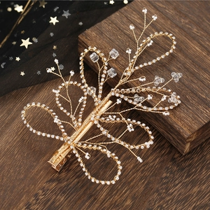 Elegant bridal gold hair clip with handmade pearls and sparkling rhinestones on wood
