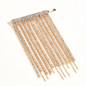 Détail d'une barrette dorée à pampilles avec strass brillants pour coiffure de soirée