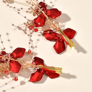 Détails de barrettes à fleurs rouges pour mariée avec feuilles dorées et perles