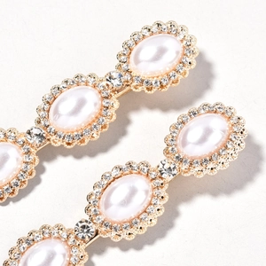 Detailed macro view of golden alloy bridal hair clip with faux pearls and rhinestones