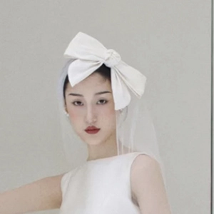 Détail d'un nœud papillon de mariée en satin blanc avec voile en tulle élégant et chic