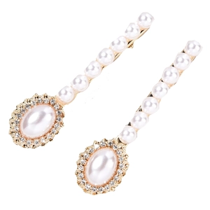 Detail view of elegant golden bridal hair clips with white pearls and sparkling rhinestones
