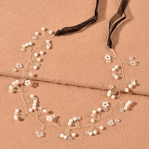 Detail of handcrafted gold wire bridal headband with pearls and crystals on wool background