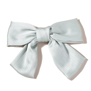Detailed top view of a large pleated mint green silk bow hairclip with long tails