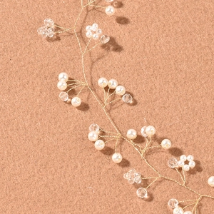 Close-up of handmade gold wire hair vine with white pearls and clear crystal beads