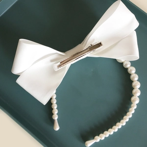 Barrette à cheveux élégante en satin blanc avec nœud et perles sur fond vert