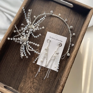 Elegant bridal hair accessory set with silver crystals and pearls on wood tray