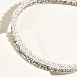 Détail macro du serre-tête élégant avec perles et strass pour coiffure de mariée