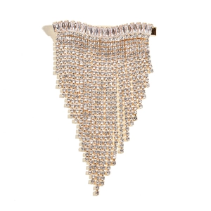 Macro detail of bridal gold hair clip with cubic zirconia and long tassel fringes
