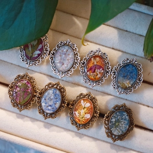 Set of 8 vintage oval floral brooches with dried flowers in bronze and silver frames