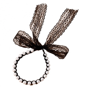 Detail of elegant faux pearl headband with a large black lace bow in vintage style