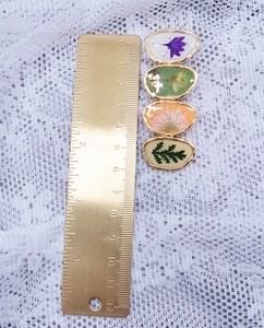 Détail de la pince à cheveux de 8,5 cm avec fleurs séchées et bordure dorée