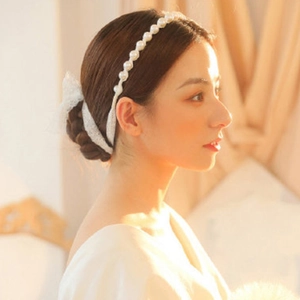 Elegant white pearl headband with large lace bow for bridal wedding hair styling
