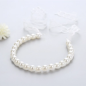 Close-up of elegant bridal pearl headband with intricate white lace ribbon ties
