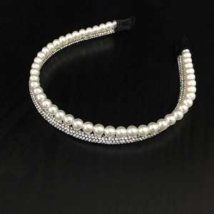 Gros plan sur un serre-tête élégant orné de perles blanches et de strass scintillants