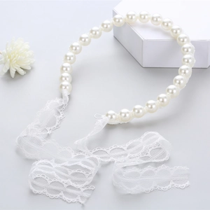 Detailed close-up of white imitation pearl headband with elegant lace ribbon ties
