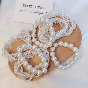 Detail of elegant white pearls and faceted crystal beads on a wooden display tray