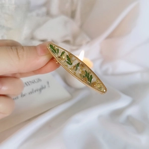 Handmade resin hair clip with real dried flowers and gold foil in wavy metal frame