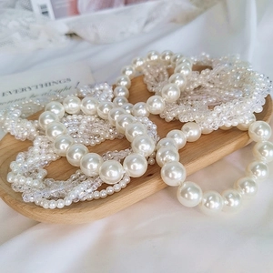 Detailed close-up of elegant pearl and crystal bead hair ties on a wooden tray
