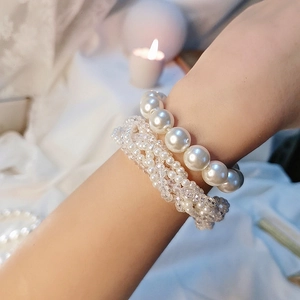 Close-up of elegant crystal pearl hair tie worn as a layered bracelet on wrist