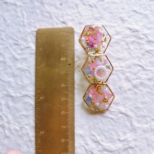 Detailed close-up showing a 6cm handmade hair clip with resin, dried flowers and gold foil