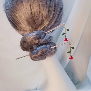 Elegant gold hair pin with double red rose tassels on a model's hair, romantic style