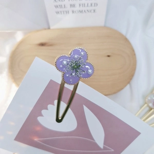 Detailed macro of a purple clover resin hair clip with dried flowers and white pearls