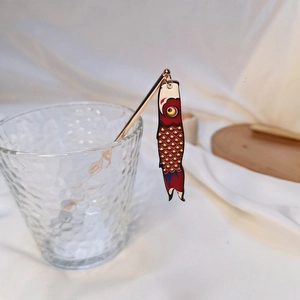 Detailed shot of a golden hair stick featuring a traditional Japanese koi carp windsock charm