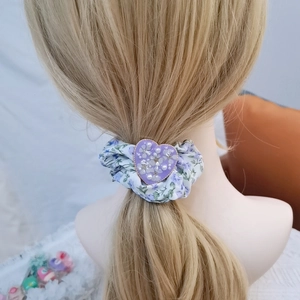 Floral purple hair scrunchie with heart detail shown on model's hairstyle