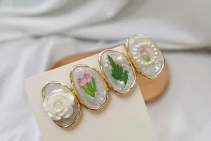 Détail d'une barrette française vintage avec tulipes, roses et perles en cadres dorés