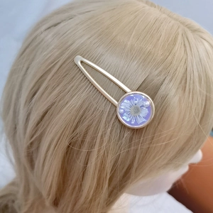 Golden triangle hair clip with purple flower resin and pearls on blonde wavy hair