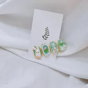 Détail de la pince à cheveux vert menthe avec motifs lapin et fleurs sur carte